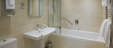 A modern bathroom with a toilet, sink, and bathtub.
