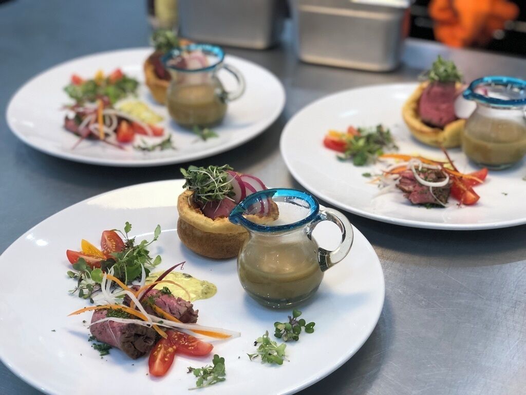 Plates of food with a glass pitcher on a table.