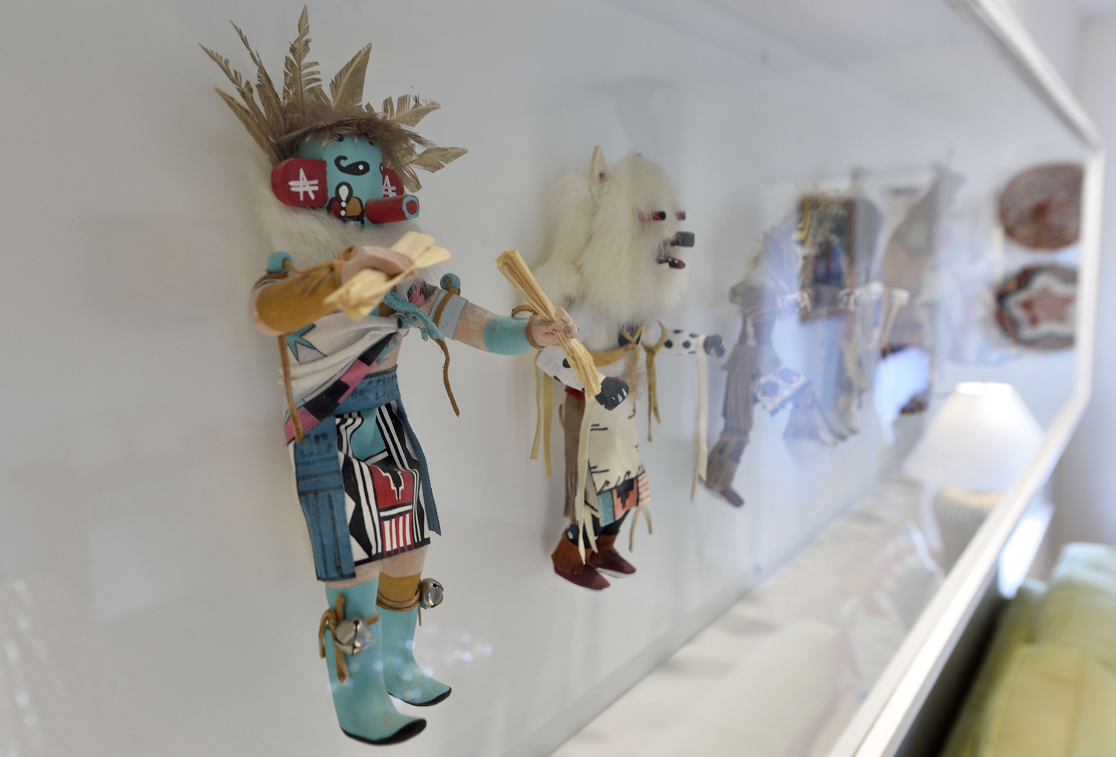 A display of various decorative items, including a figure with a crown and a dog-like figure, mounted on a wall.