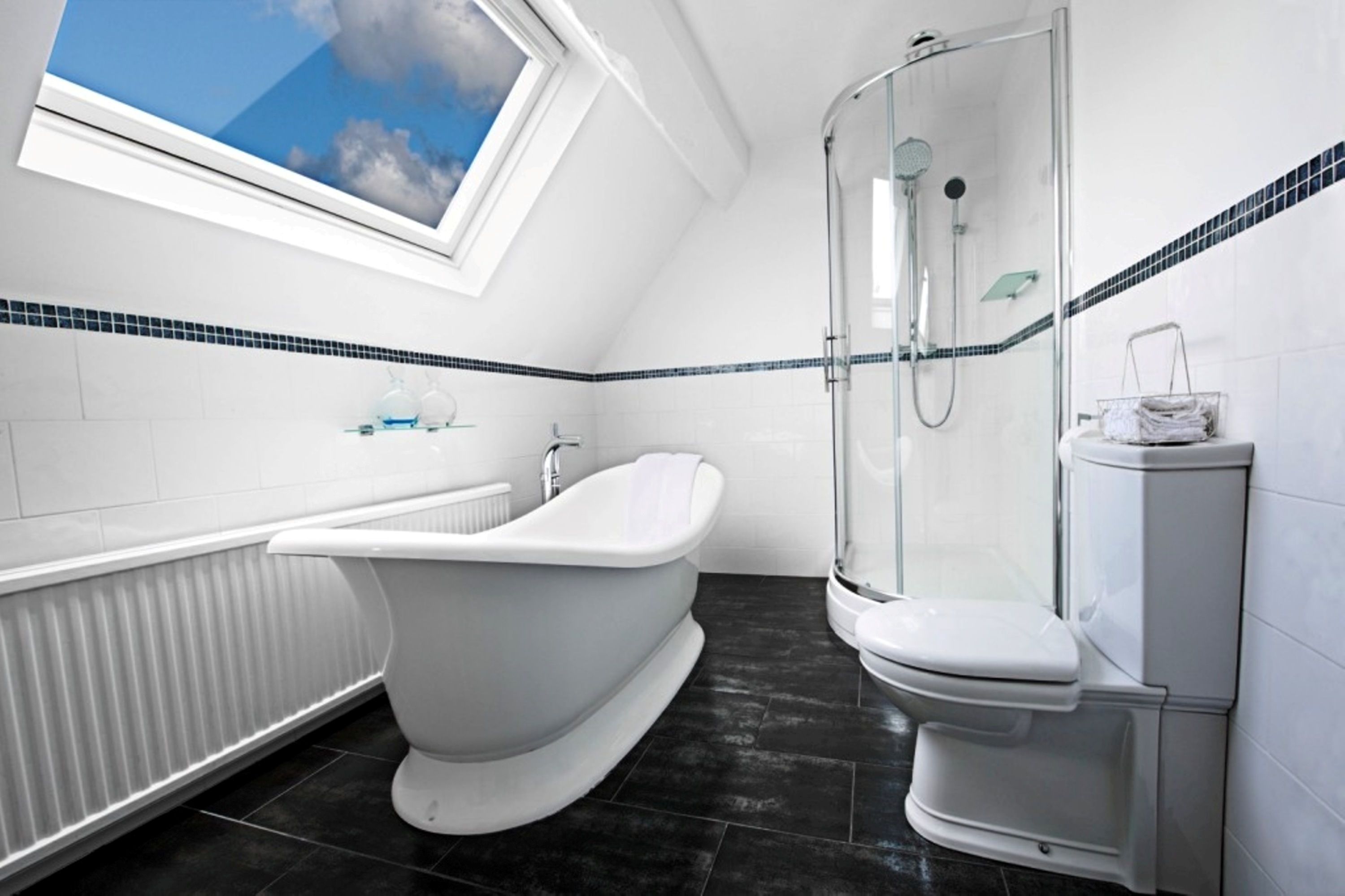 A modern bathroom with a freestanding bathtub, a glass-enclosed shower, and a toilet.