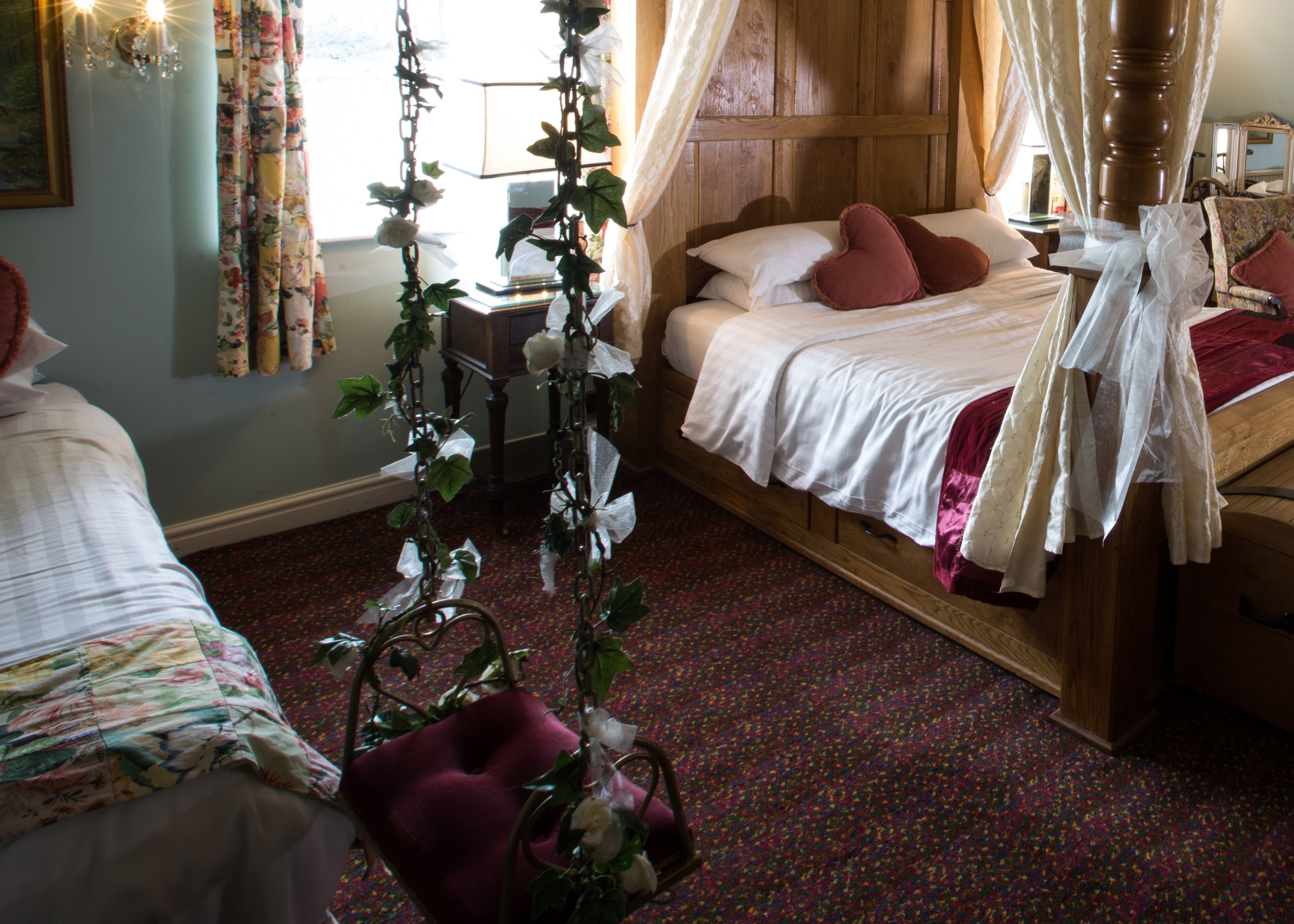 Un dormitorio con una cama de madera, dosel y un arreglo floral.