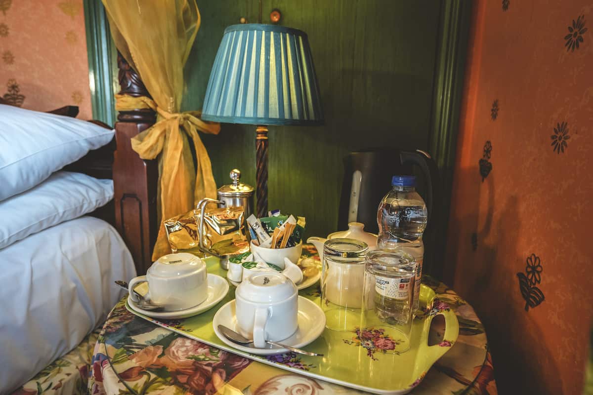 A neatly arranged breakfast table with tea, cups, and a teapot.