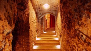 A stone staircase leading to a higher level, with a red curtain at the top. - Oste del Castello Wellness & Bike Hotel (Verucchio)