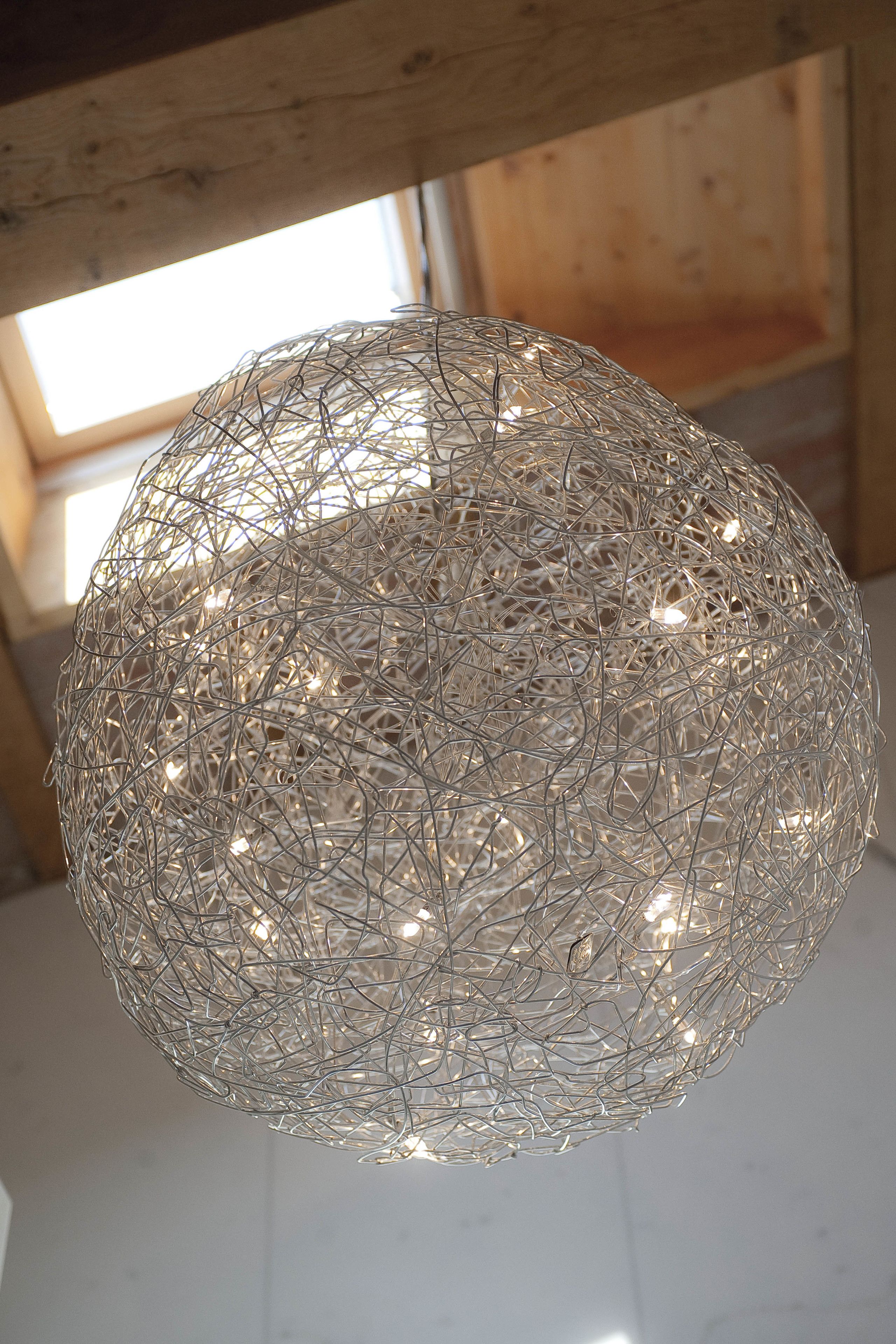 Un lustre sphérique en métal, doté de plusieurs ampoules.