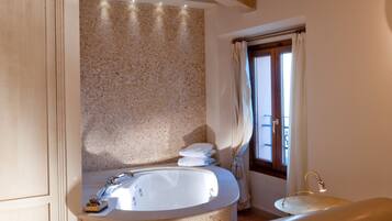 Une salle de bain avec une baignoire, un plafond en bois et une fenêtre avec des rideaux.