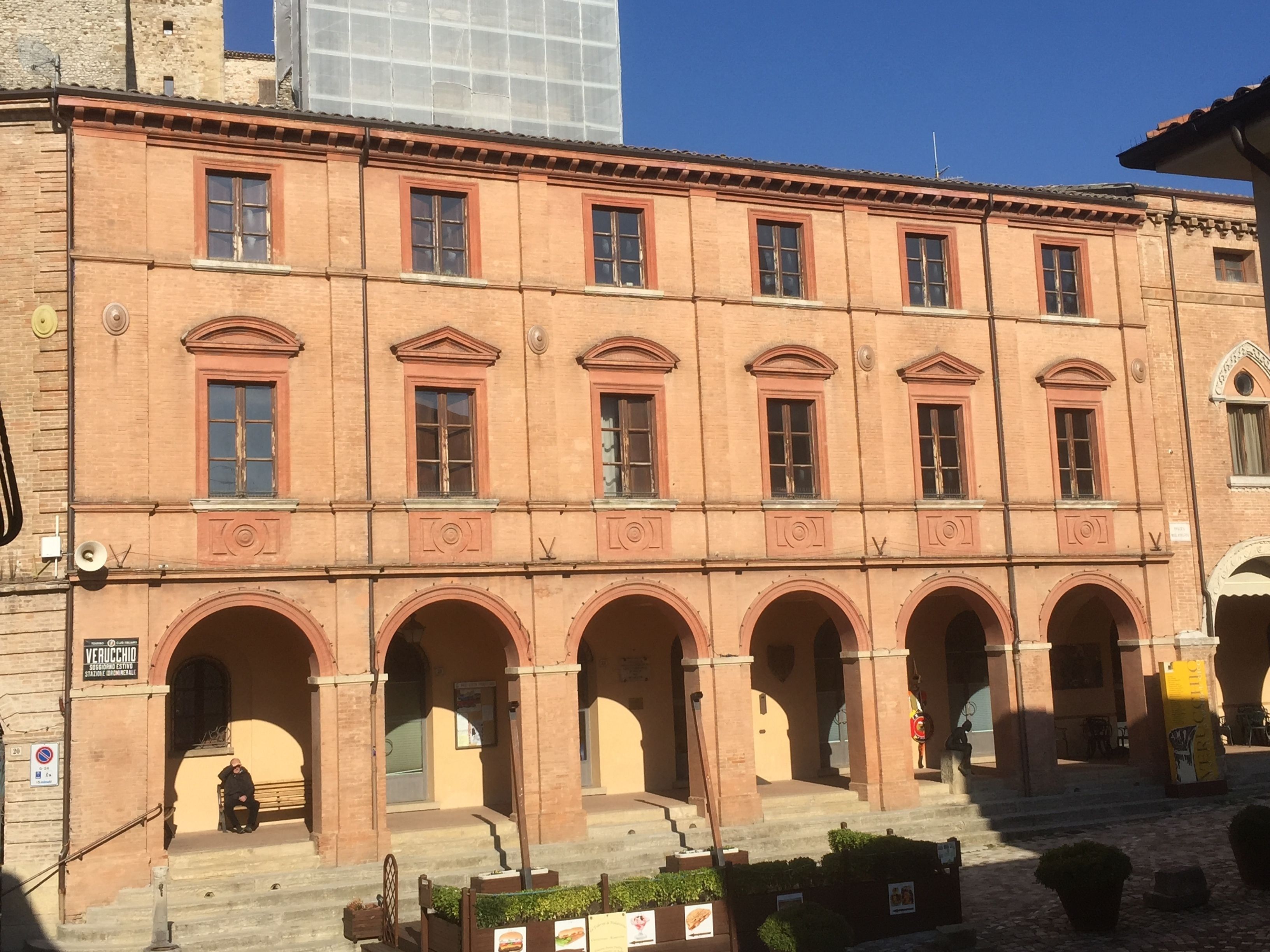 Un edificio histórico con un patio central, arcos y una escalera que conduce a la entrada.