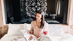 A person sitting on a bed with a tray of breakfast items, a book, and a cup of coffee. - Oste del Castello Wellness & Bike Hotel (Verucchio)