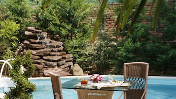 Una piscina al aire libre de temporada, sillones reclinables de piscina