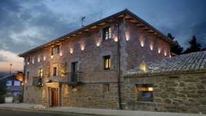 A stone building with multiple windows and balconies, featuring a traditional architectural style.