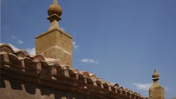 A building with a terracotta roof and a stone facade.