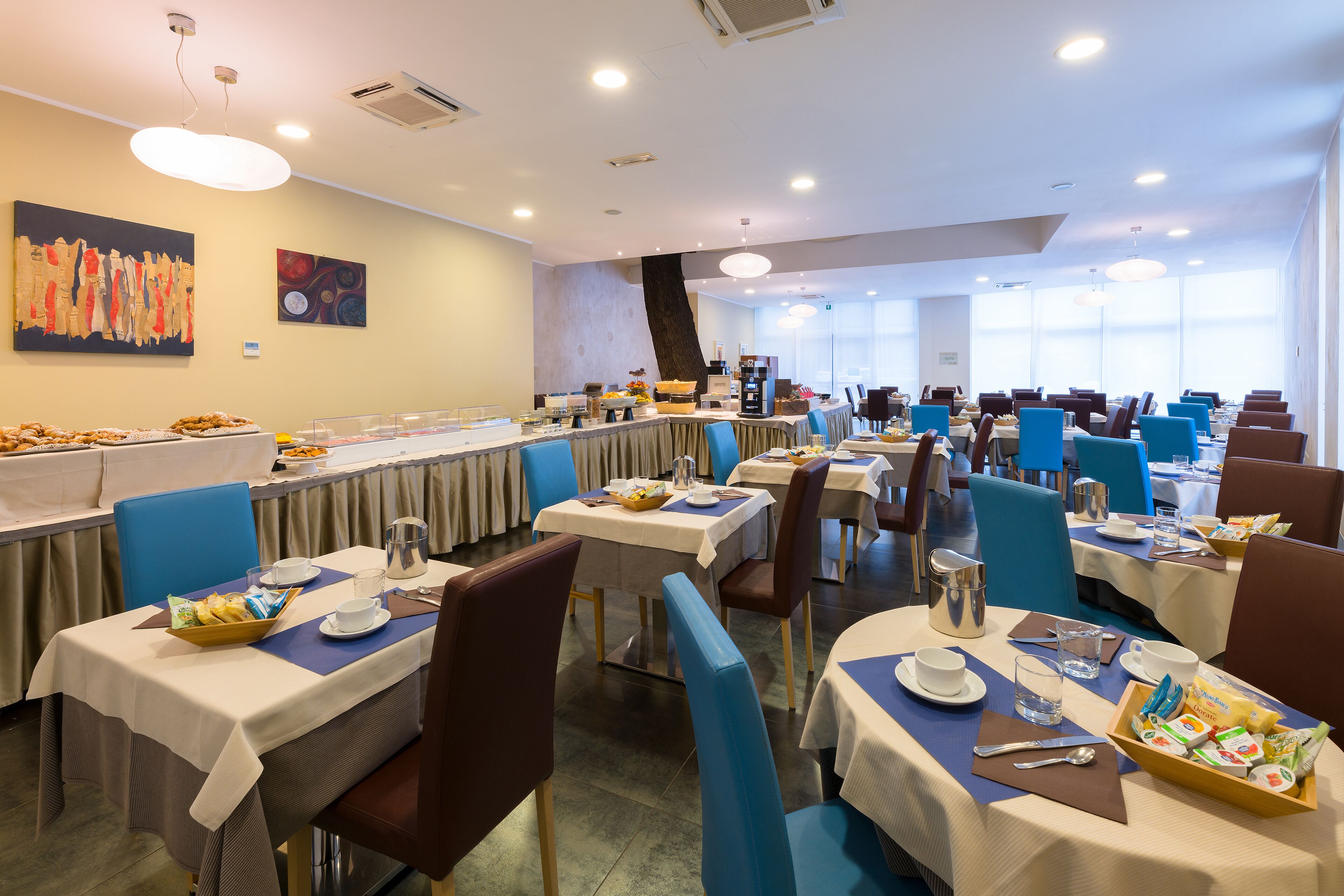 A dining area with multiple tables, chairs, and buffet stations.