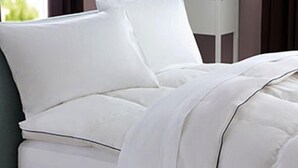 A bed with white bedding and a pillow. - Hotel Baja  (Arzachena)