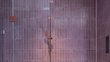 A modern bathroom with a large shower area, a glass enclosure, and a wall-mounted control panel.