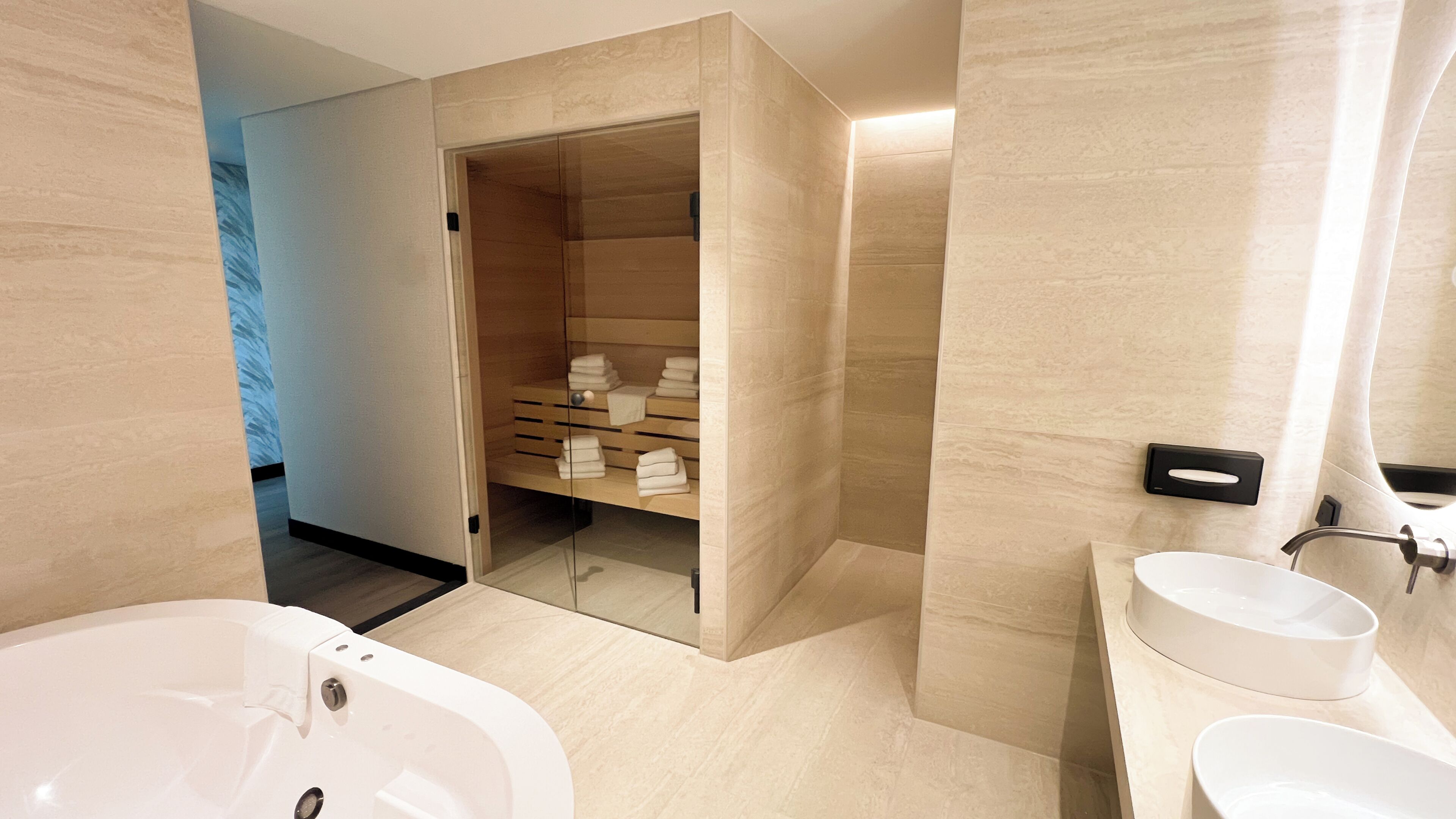 A modern bathroom with a large bathtub, a sink, and a shower area with a glass door.