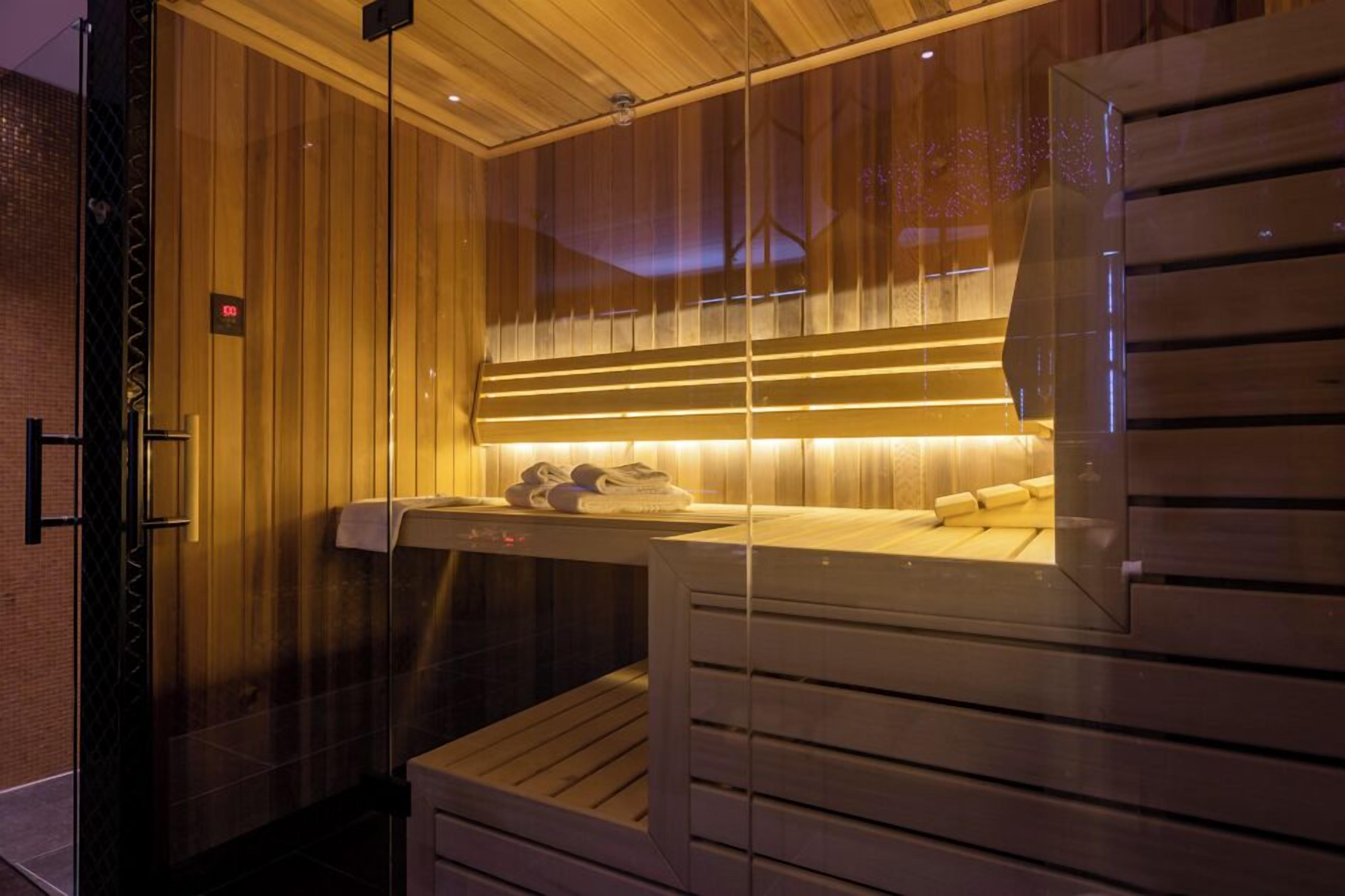 A sauna room with wooden panels, a bench, and a towel rack.