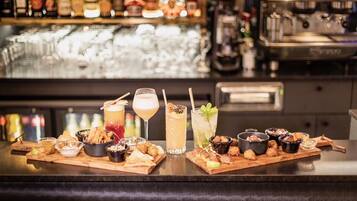 A bar with a variety of drinks and snacks on wooden boards.