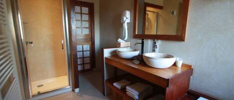 Un baño con tocador de madera, un espejo grande y una bañera.