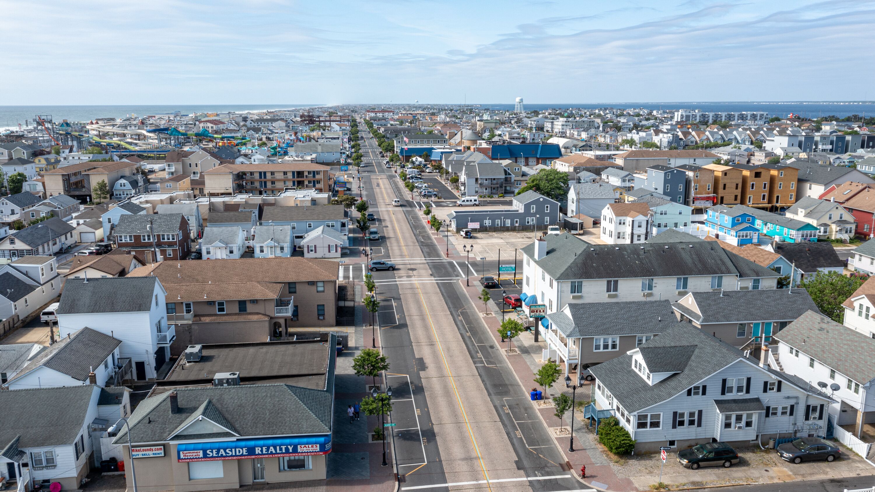 A coastal town with a mix of residential and commercial buildings, including a hotel with a visible sign.
