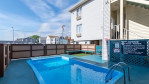 Piscina residencial con muelle de madera y borde azul.