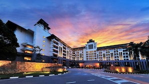 A multi-story hotel with a modern architectural design, featuring a central courtyard and a well-lit entrance. - Pulai Springs Resort (Johor Bahru)