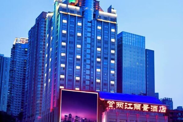 A high-rise hotel with a prominent neon sign indicating it is a hotel.