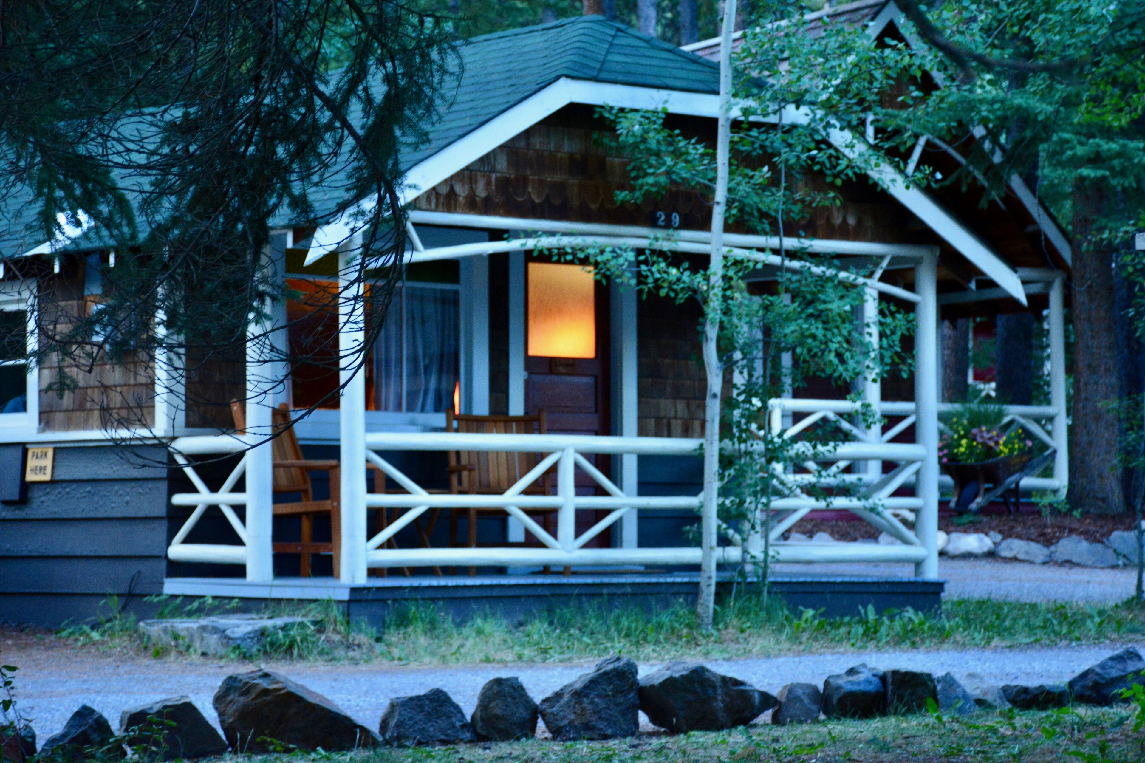 A cabin with a porch, wooden exterior, and a visible number '29'.