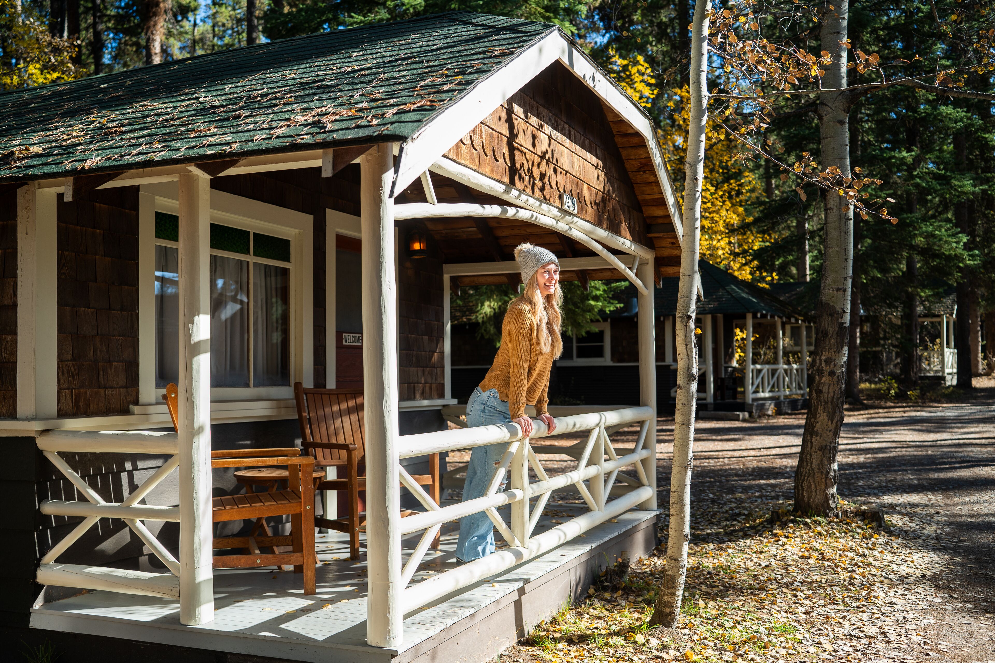 Une cabane en bois avec une véranda, une table et des chaises.