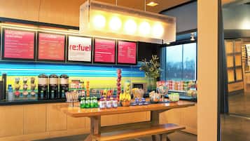 A breakfast bar with a menu board displaying breakfast options and a selection of beverages.