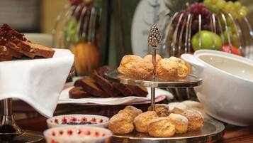 Un bufé con diversos alimentos, incluyendo pasteles y frutas.