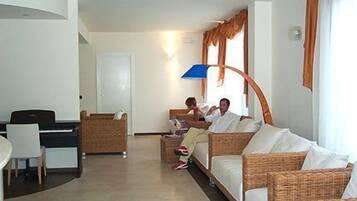 Ein Hotelzimmer mit Essbereich, einer Sofagarnitur und einem Schreibtisch.