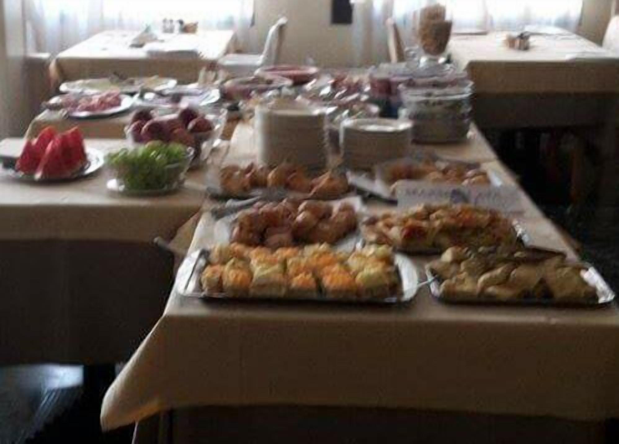 A buffet table with various food items and utensils.