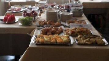 A buffet table with various food items and utensils.