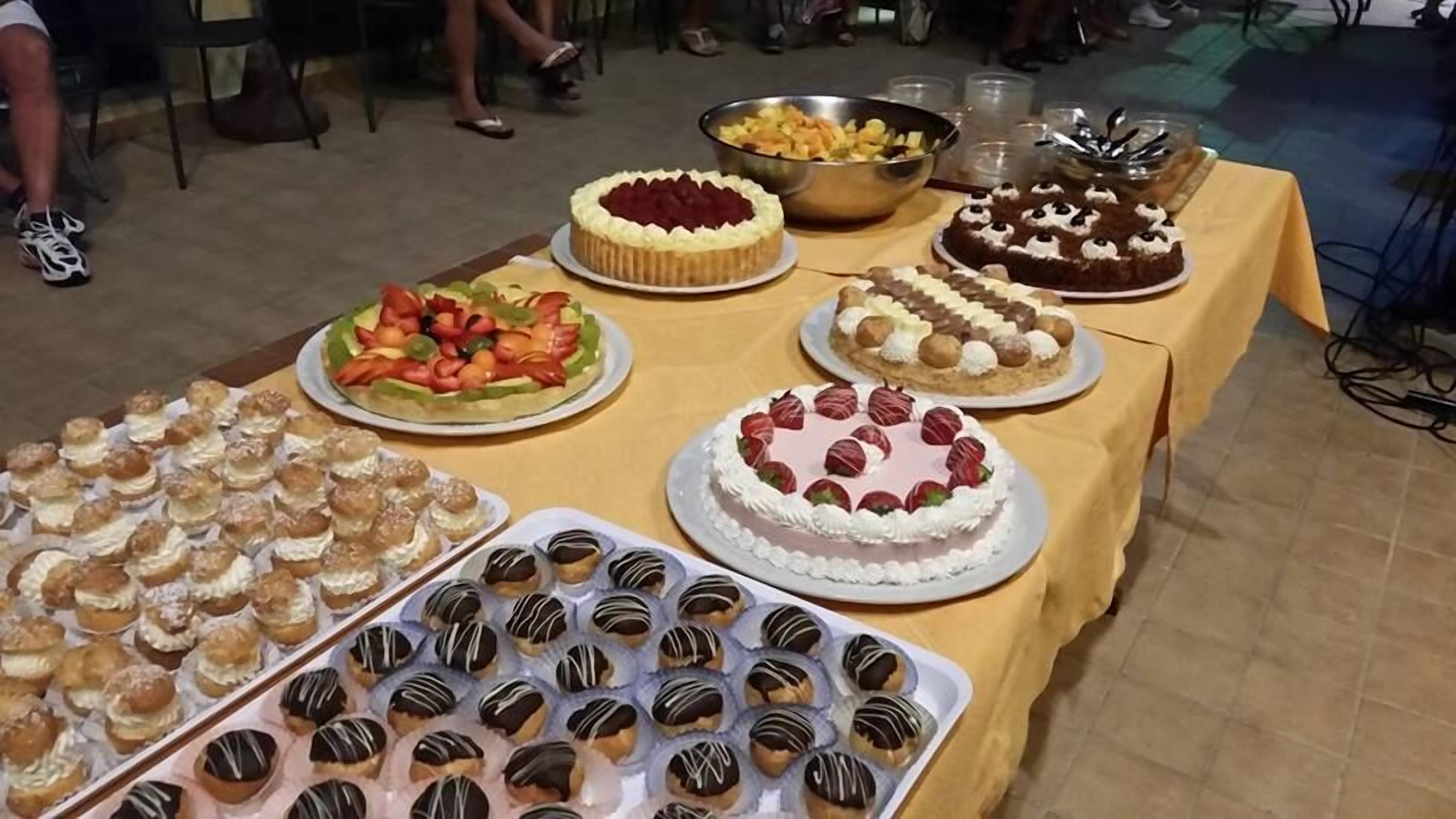 Ein Buffet mit verschiedenen Desserts, darunter Kuchen, Gebäck und Obst.