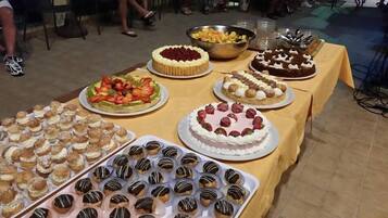 Ein Buffet mit verschiedenen Desserts, darunter Kuchen, Gebäck und Obst.