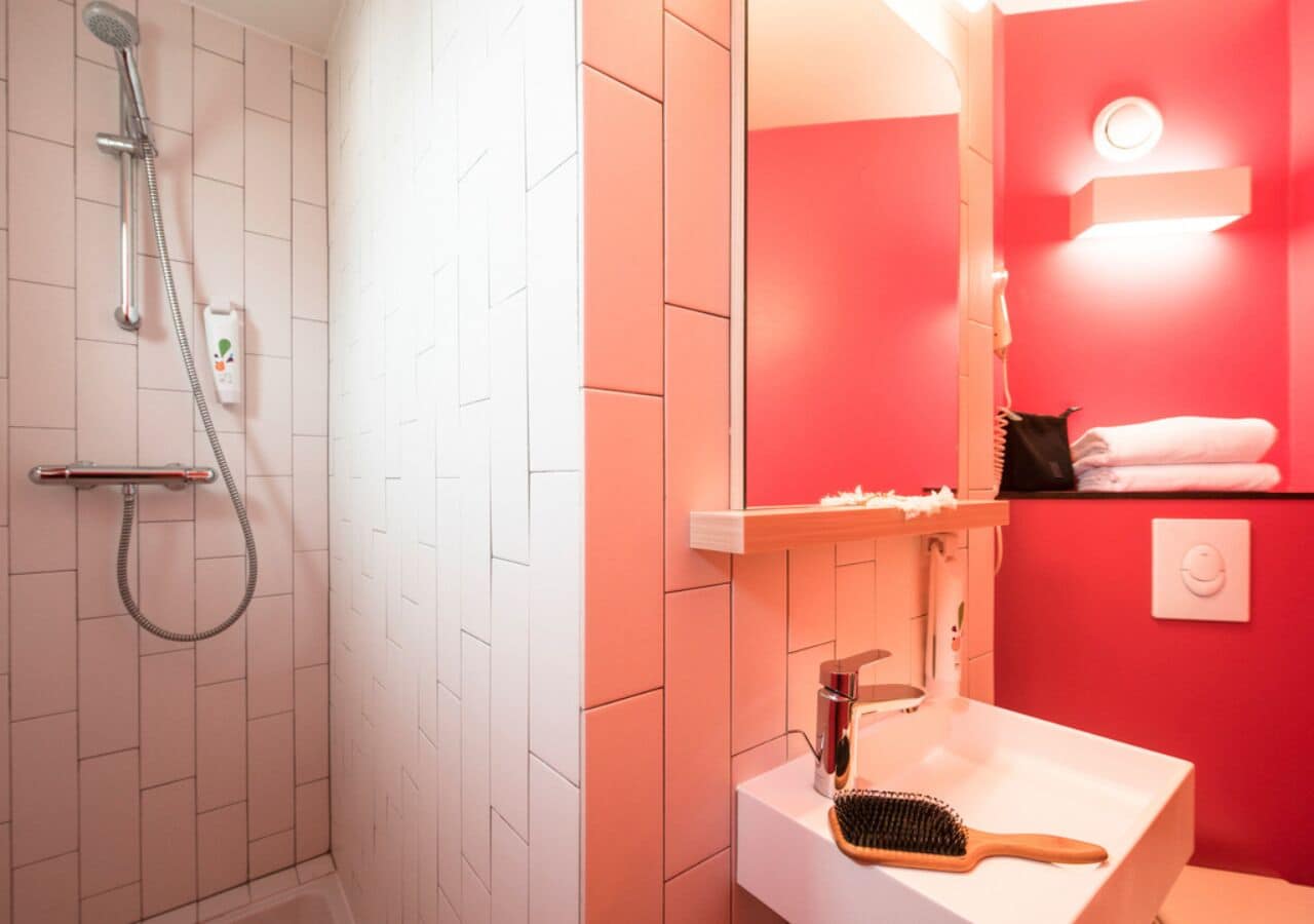 Un baño con ducha, lavamanos y espejo.