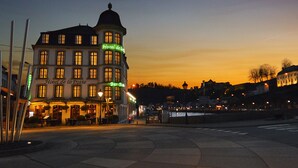 A historic building with multiple stories, featuring a prominent corner tower and a ground-level bar. - Hotel de la Poste - Relais Napoléon III (Bouillon)
