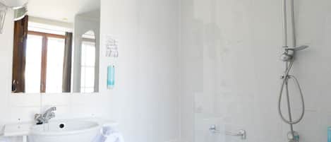 A modern bathroom with a shower, sink, and toilet.