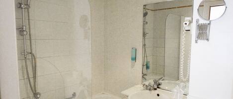 Un baño con ducha de vidrio, bañera, lavamanos e inodoro.