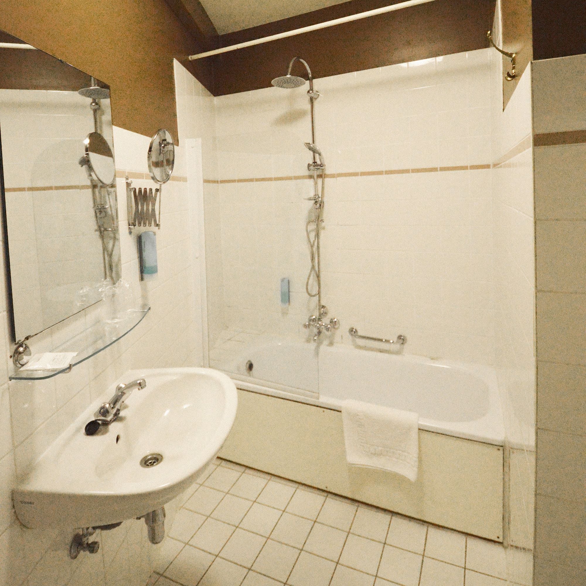 Ein Badezimmer mit Waschbecken, Spiegel und Badewanne.