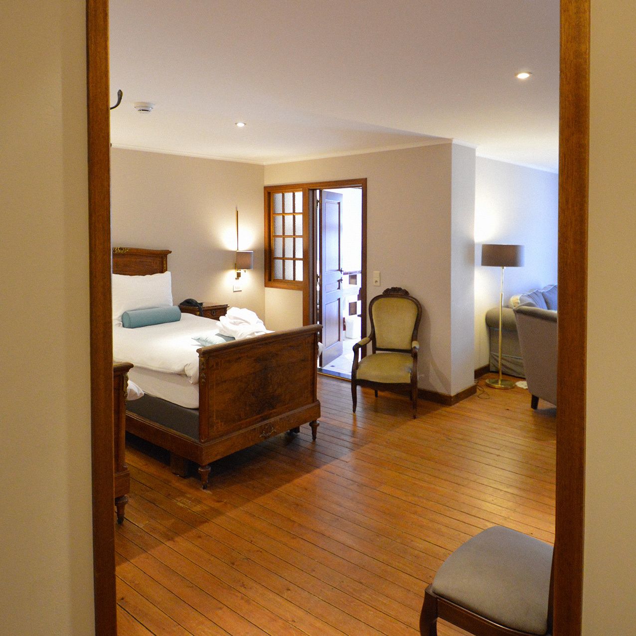 Une chambre à coucher avec un lit en bois, une chaise et une table de chevet.