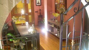 Una habitación con escalera, un comedor y vistas a través de un arco.