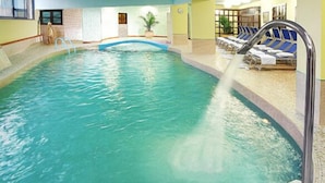 An indoor swimming pool with clear water, a diving board, and lounge chairs along the side. - Sporting Baia Hotel (Giardini Naxos)