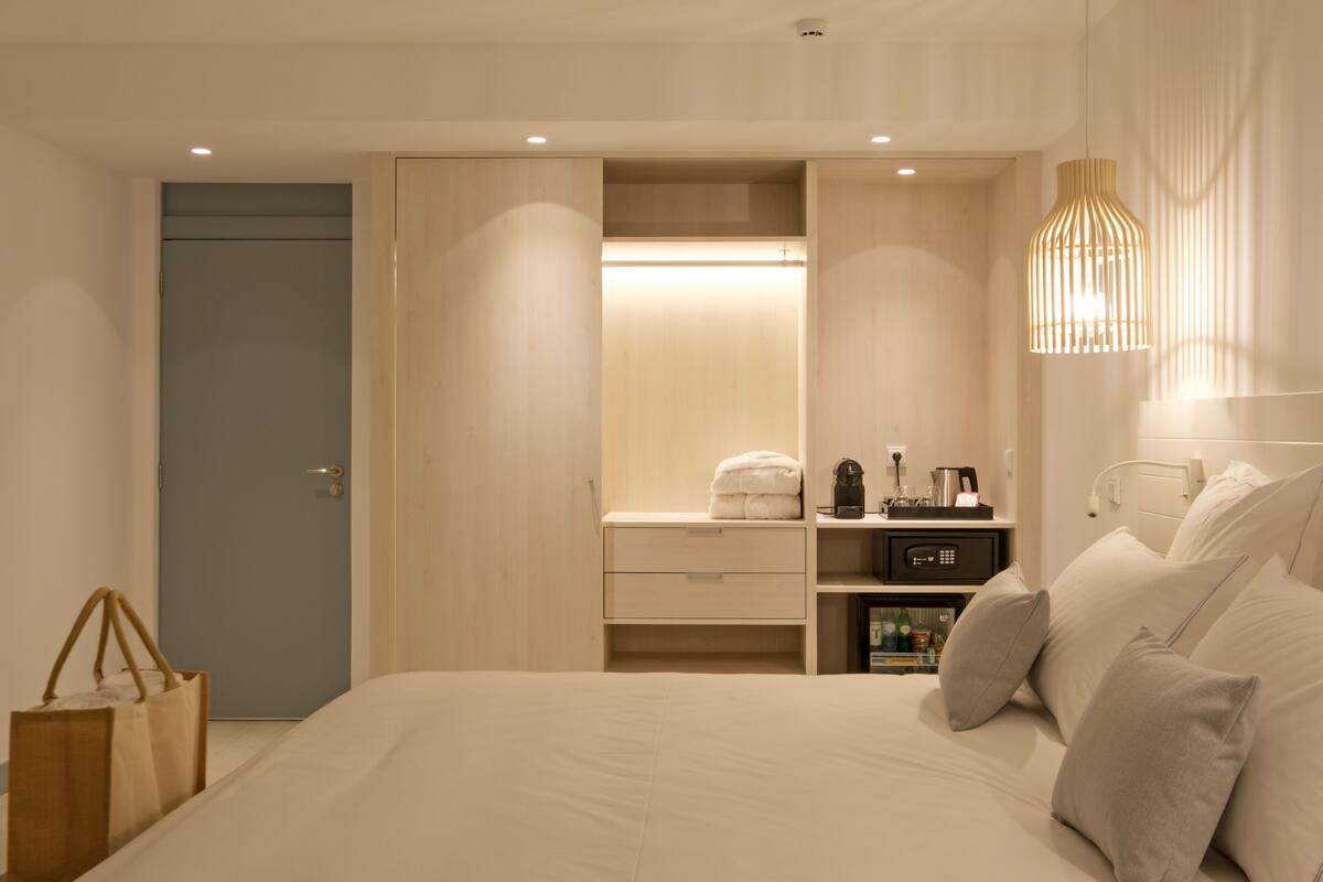 Ein modernes Schlafzimmer mit Bett, Nachttisch und Kleiderschrank.
