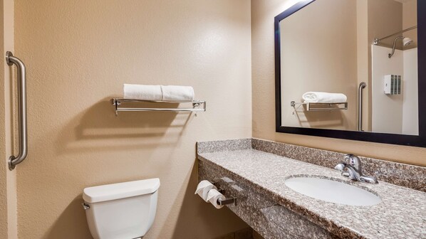 Un baño con inodoro, lavamanos y toallero.