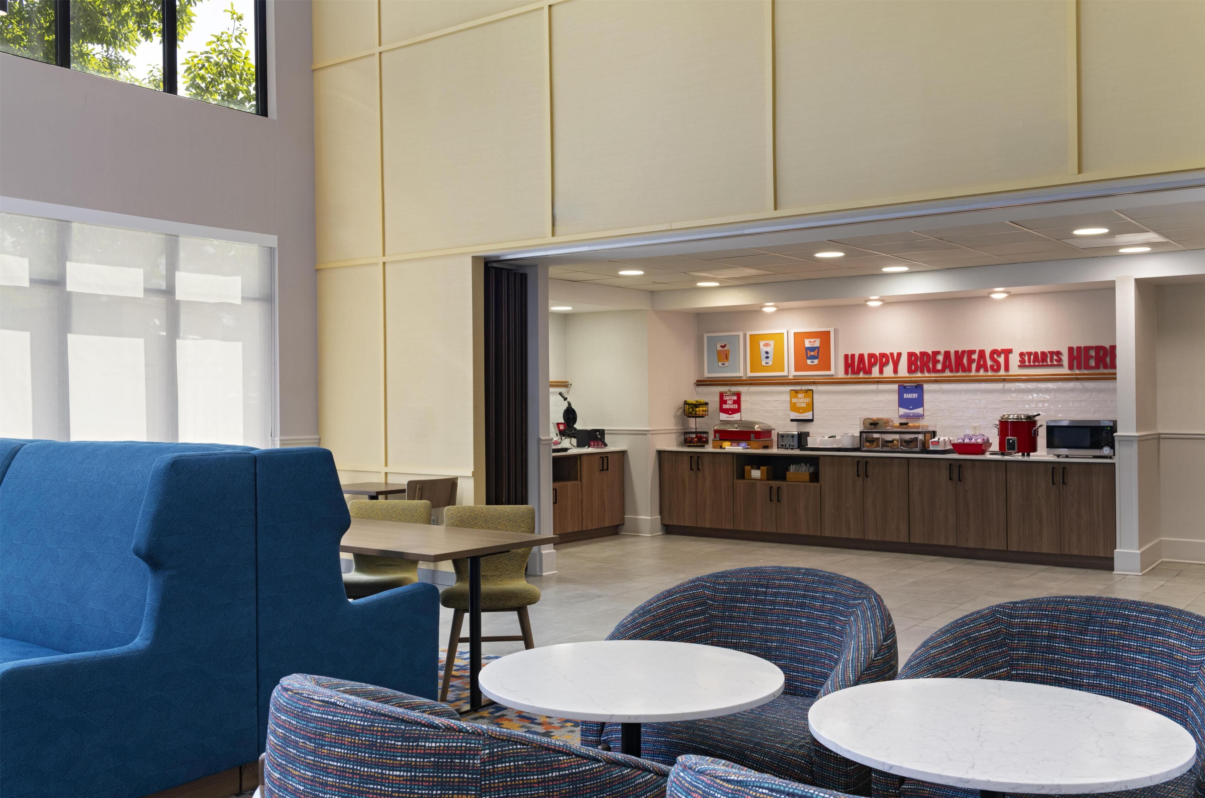 A modern breakfast area with seating and a bakery counter.