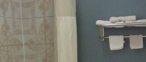 A bathroom with a bathtub, toilet, and a shower curtain.