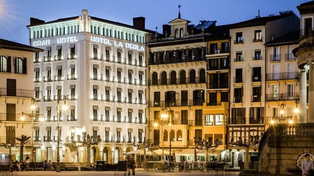 Un hotel con varios pisos, balcones y un letrero llamativo.