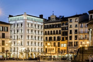Un hotel con varios pisos, balcones y un letrero llamativo.