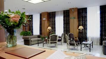 Vestíbulo de hotel con mostrador de recepción, zona de estar y un letrero que indica la salida.