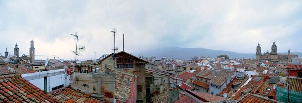 Un paisaje urbano con arquitectura tradicional, incluyendo edificios con tejados de baldosas rojas y una iglesia destacada con un campanario.